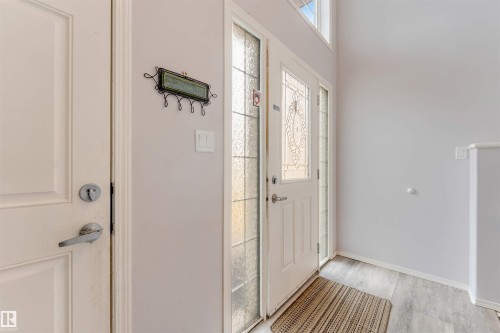 Entryway featuring a white paneled door with decorative glass inserts, a frosted glass sidelight, and a transom window - 123 Rue Masson, Beaumont, AB - Indoor Photo Showing Other Room