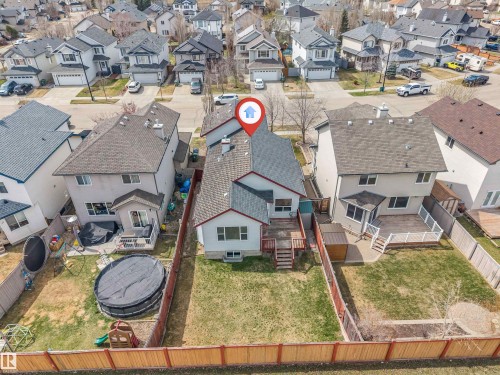 Rear exterior featuring a spacious wood deck, ground-level patio, and fenced backyard - 123 Rue Masson, Beaumont, AB - Outdoor With View