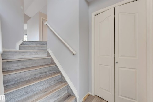 Staircase featuring wood-finish treads and risers, white trim, and a white handrail - 123 Rue Masson, Beaumont, AB - Indoor Photo Showing Other Room