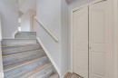 Staircase featuring wood-finish treads and risers, white trim, and a white handrail - 123 Rue Masson, Beaumont, AB  - Indoor Photo Showing Other Room 
