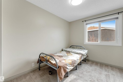 This room features light-colored walls, a window with white trim, and a ceiling light fixture - 37 1411 Mill Woods Road E, Edmonton, AB - Indoor Photo Showing Bedroom