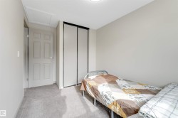 This room features light-colored walls, grey carpet flooring, and a white six-panel door - 