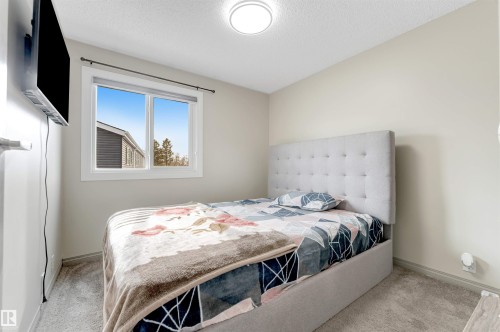 This room features a window providing natural light, light-colored walls, and carpeting - 37 1411 Mill Woods Road E, Edmonton, AB - Indoor Photo Showing Bedroom