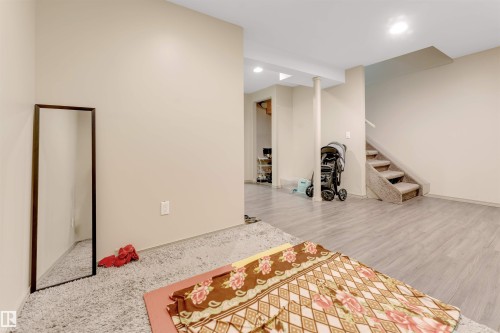 This property features a spacious room with light-colored walls and a combination of light wood-style flooring and carpet - 37 1411 Mill Woods Road E, Edmonton, AB - Indoor