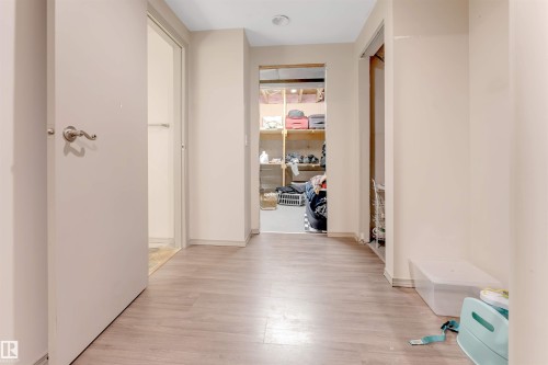 Corridor featuring light-colored walls and wood-style flooring - 37 1411 Mill Woods Road E, Edmonton, AB - Indoor Photo Showing Other Room