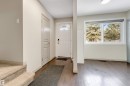 The entry features rich dark wood flooring and a bright white front door with an arched window insert - 37 1411 Mill Woods Road E, Edmonton, AB  - Indoor Photo Showing Other Room 