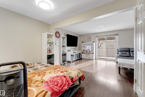 Living area featuring hardwood flooring and sliding glass doors that lead to an outdoor space - 37 1411 Mill Woods Road E, Edmonton, AB - Indoor Photo Showing Bedroom