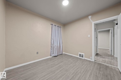 Neutral wall color, wood-finish flooring, and white trim - 11414 85 Street, Edmonton, AB - Indoor Photo Showing Other Room