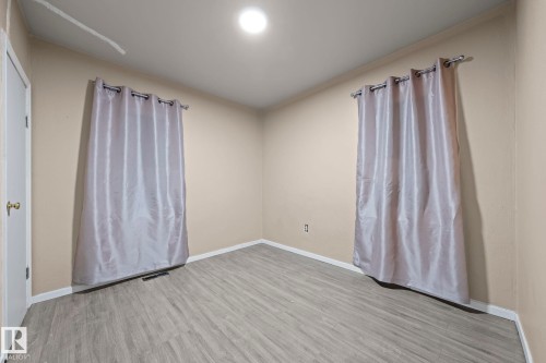 Room featuring light wood-finish flooring, neutral wall paint, and white baseboards - 11414 85 Street, Edmonton, AB - Indoor Photo Showing Other Room