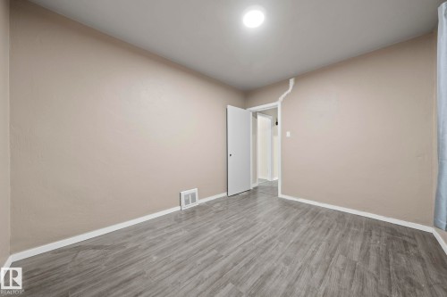 Room featuring wood-finish flooring, neutral wall tones, and white baseboards - 11414 85 Street, Edmonton, AB - Indoor Photo Showing Other Room