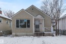 Stucco-finish exterior with a covered front porch featuring white railings - 11414 85 Street, Edmonton, AB  - Outdoor 