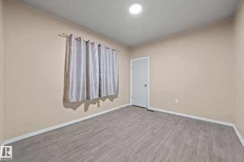Room featuring neutral-toned walls, wood-finish flooring, a flush-mount ceiling light, and white trim - 11414 85 Street, Edmonton, AB - Indoor Photo Showing Other Room
