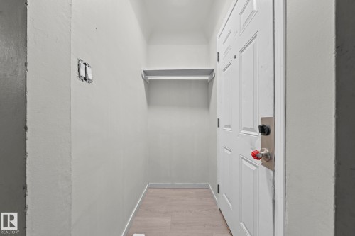 Entryway with wood-finish flooring, a white paneled door, and a built-in shelf - 11414 85 Street, Edmonton, AB - Indoor