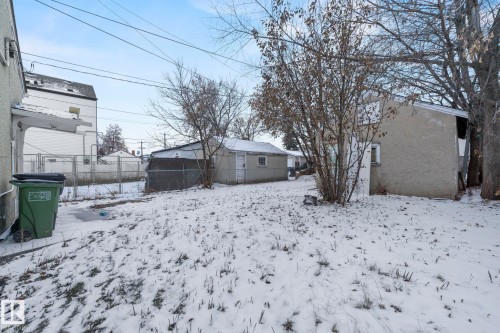 Expansive backyard featuring a chain-link fence, mature trees, and two detached outbuildings - 11414 85 Street, Edmonton, AB - Outdoor
