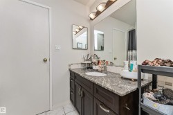Vanity featuring a dark wood-finish base cabinet, an integrated sink, and a stone-finish countertop - 