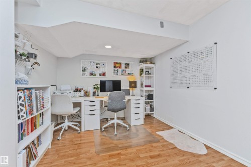 Versatile room featuring wood-finish flooring, white walls, and built-in shelving - 49 Ash Crescent, St. Albert, AB - Indoor Photo Showing Office