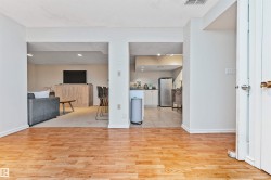 Wood-finish flooring throughout the foreground leading to distinct open archways - 