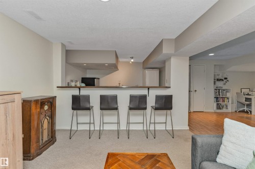 Lower-level recreation space featuring a wet bar with wood-finish countertop, recessed lighting, and soft carpet flooring - 49 Ash Crescent, St. Albert, AB - Indoor Photo Showing Other Room