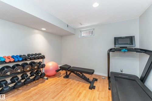 Recreational room with wood-finish flooring and recessed lighting - 49 Ash Crescent, St. Albert, AB - Indoor