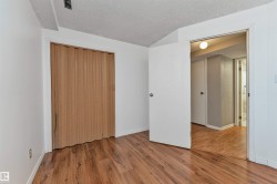 Room featuring wood-finish flooring, white walls, and a textured ceiling - 