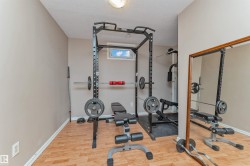 Dedicated exercise room featuring wood-finish flooring, neutral wall tones, and a built-in window providing natural light - 