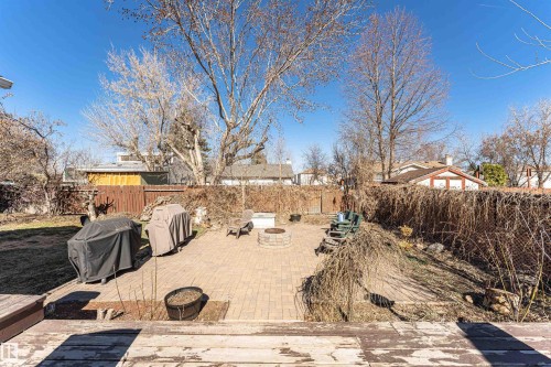 Spacious outdoor patio with paver flooring, a built-in fire pit, and mature trees - 49 Ash Crescent, St. Albert, AB - Outdoor