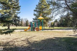 Park playground featuring a yellow slide, colorful climbing structure, and sand base - 