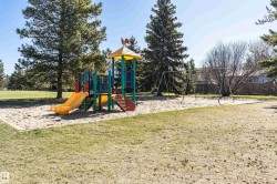 Outdoor playground featuring a colorful play structure with slides and a swing set - 