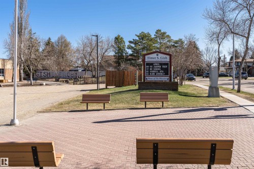 Brick paver walkway with wood benches, surrounded by landscaped green spaces and mature trees - 49 Ash Crescent, St. Albert, AB - Outdoor