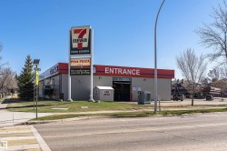 Commercial building featuring a prominent 7-Eleven sign, Pisa Pizza signage, and a liquor store sign - 