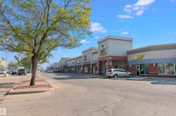 Retail strip center featuring a brick facade with stone accents and multiple storefronts - 