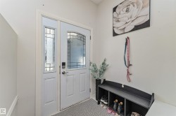 Entryway featuring a white paneled door with an arched leaded glass insert, complemented by a sidelight with clear and frosted glass - 