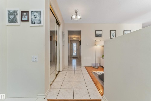 Tiled entryway with mirrored closet doors and a flush-mount ceiling light fixture - 49 Ash Crescent, St. Albert, AB - Indoor Photo Showing Other Room