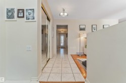 Tiled entryway with mirrored closet doors and a flush-mount ceiling light fixture - 