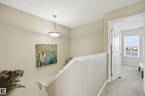 Carpeted upper-level hallway with neutral wall tones and a ceiling-mounted pendant light fixture - 481 Sheppard Boulevard, Leduc, AB - Indoor Photo Showing Other Room