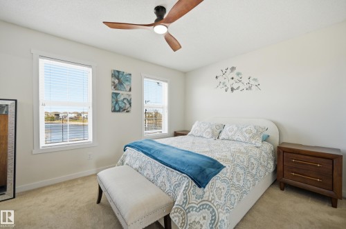 Bright bedroom with two windows offering water views - 481 Sheppard Boulevard, Leduc, AB - Indoor Photo Showing Bedroom