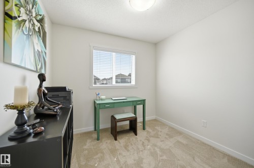 Carpeted room featuring a single window with blinds, white walls, and a ceiling-mounted light fixture - 481 Sheppard Boulevard, Leduc, AB - Indoor