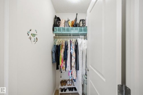 Walk-in closet featuring built-in wire shelving, hanging rod storage, and a white paneled door - 481 Sheppard Boulevard, Leduc, AB - Indoor