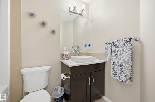 Modern vanity with a rectangular vessel sink, stone-look countertop, and dark wood-finish cabinetry - 481 Sheppard Boulevard, Leduc, AB - Indoor Photo Showing Bathroom