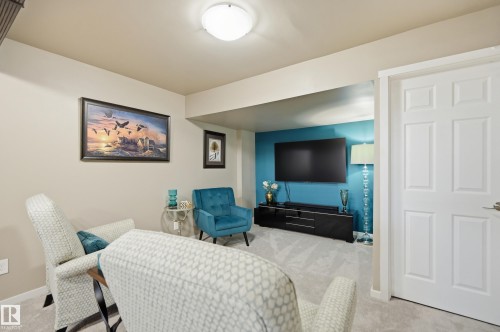 Carpeted interior space featuring a recessed accent wall, a six-panel interior door, and a flush-mount ceiling light fixture - 481 Sheppard Boulevard, Leduc, AB - Indoor
