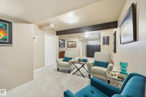 Carpeted recreation room featuring neutral wall tones and a wood-finish beam - 481 Sheppard Boulevard, Leduc, AB - Indoor