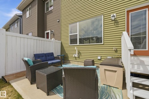 Concrete patio featuring a white privacy fence and a rear exterior door with glass insert - 481 Sheppard Boulevard, Leduc, AB - Outdoor With Deck Patio Veranda With Exterior