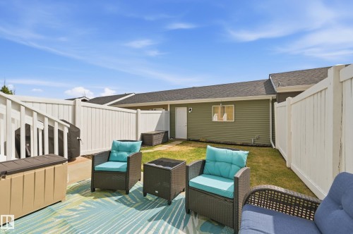 Outdoor patio area featuring a decorative area rug, a privacy fence, and a grassy backyard space - 481 Sheppard Boulevard, Leduc, AB - Outdoor With Deck Patio Veranda With Exterior