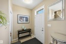 Entryway featuring a white paneled door with an overhead transom window, beige wall paint, light-toned tile flooring, and a flush-mount ceiling light fixture - 481 Sheppard Boulevard, Leduc, AB  - Indoor Photo Showing Other Room 