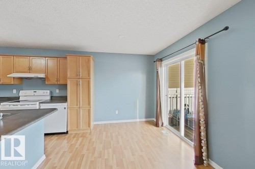 The property features a kitchen with light wood cabinetry, white appliances, and a gray countertop - 3347 24 Avenue, Edmonton, AB - Indoor Photo Showing Kitchen