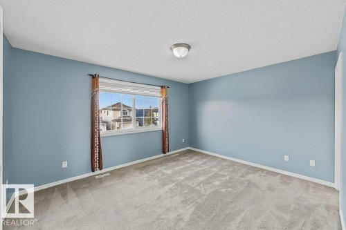 This room features light blue walls and grey carpet flooring - 3347 24 Avenue, Edmonton, AB - Indoor Photo Showing Other Room