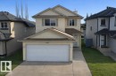 The property features a two-story exterior with light-colored siding, a garage with a driveway, and a well-maintained lawn - 3347 24 Avenue, Edmonton, AB  - Outdoor With Facade 