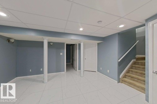 Spacious room featuring light blue walls, white tiled flooring, and recessed lighting - 3347 24 Avenue, Edmonton, AB - Indoor Photo Showing Other Room
