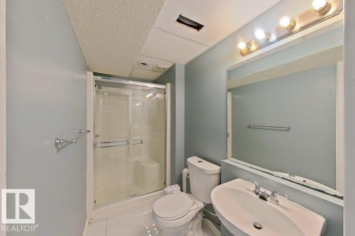 This bathroom features a shower with sliding glass doors, a toilet, and a sink with a chrome faucet - 3347 24 Avenue, Edmonton, AB - Indoor Photo Showing Bathroom