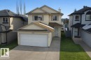 The property features an attached garage with a white garage door, a paved driveway, and a front lawn - 3347 24 Avenue, Edmonton, AB  - Outdoor With Facade 